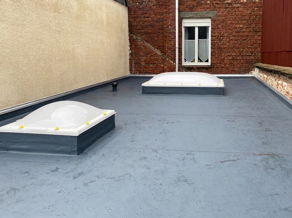 Toiture-terrasse plate avec deux lanterneaux à dôme double peau en polycarbonate translucide, montés sur costières en GRP gris anthracite
