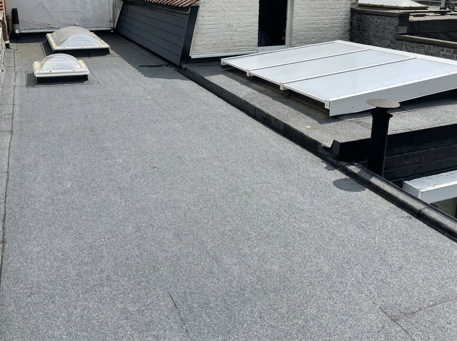Toiture-terrasse plate vue de dessus, recouverte d'une membrane bitumineuse minérale gris ardoise
