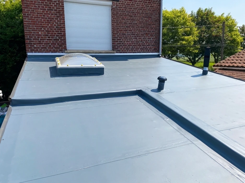 Toiture terrasse rénovée vue en plongée, membrane d'étanchéité PVC gris clair, relevés de bordure en zinc anthracite