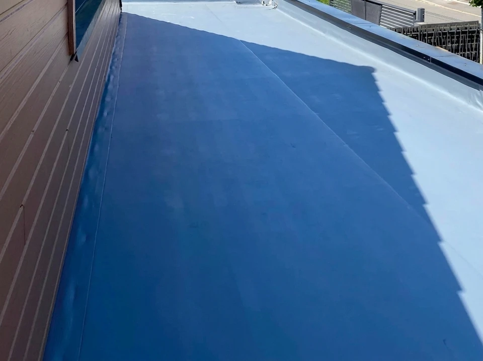 Toiture-terrasse commerciale en membrane EPDM noire avec joints d'étanchéité visibles